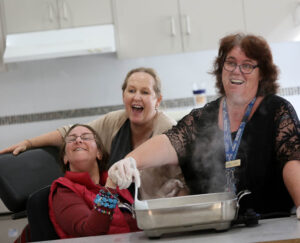 A woman with disability learning to cook with Northcott support staff