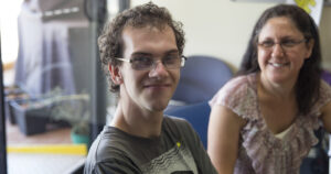 Raymond Clough sitting down smiling with his mother Stephanie