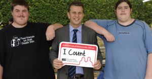 Former NSW Disability Services Minister Andrew Constance holding a sign that says "I Count". Northcott's Transition to Work customers are beside him