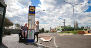 Northcott customer and support worker at a bus stop