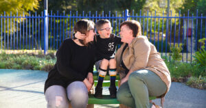 Little boy wearing orthotics, embracing his family.