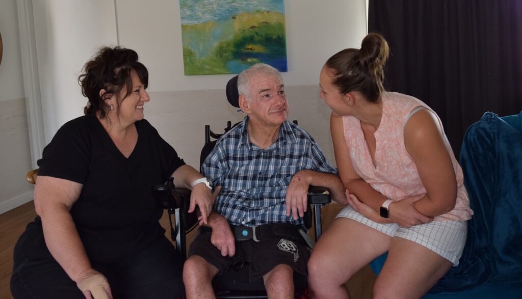 Northcott customer Bob sitting inbetween his support workers