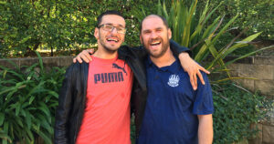Northcott support workers and customers Granit and Tony smiling with their arms around each other