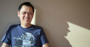 Man with short dark hair smiles at camera