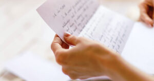 Anonymous young woman reading letter (no faces)