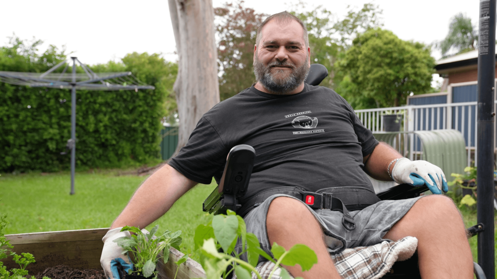 Matt is working with plants on a raised garden bed