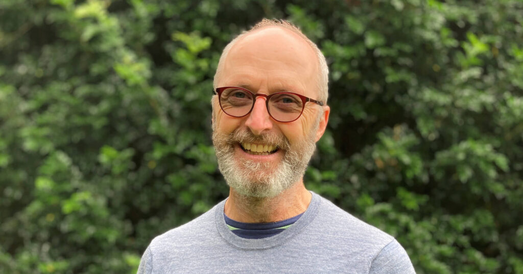 Male wearing glasses smiling at the camera