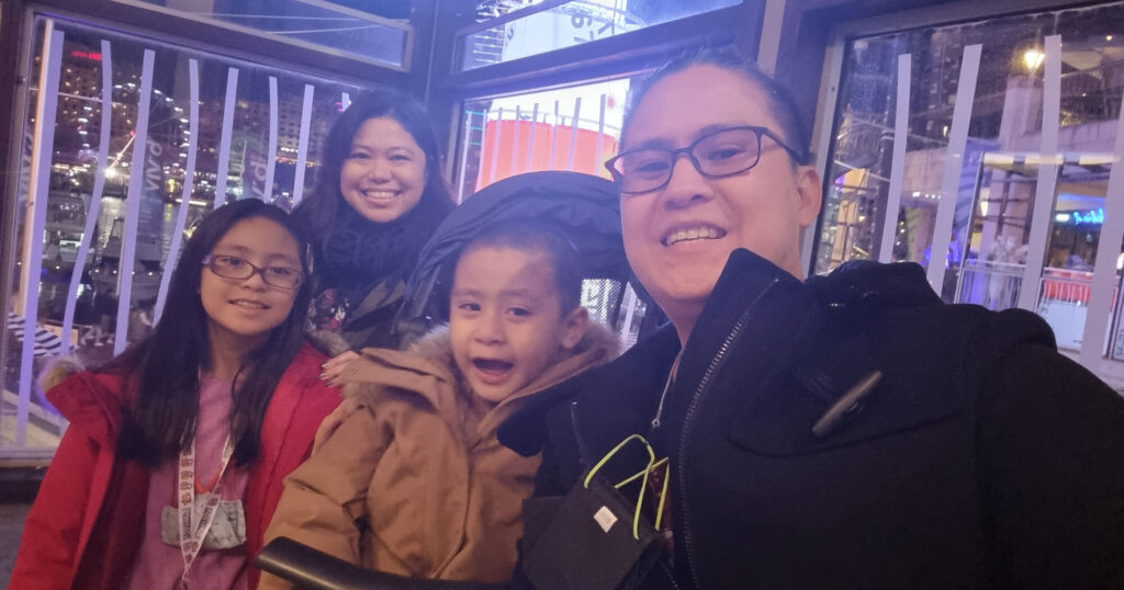 Family selfie of father, son, daughter and mother in an indoor venue