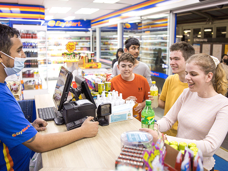 Teenagers paying for an item at a convenience store