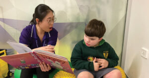 Occupational Therapist teaching young male to read
