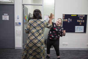 Seven Hills Customer Gracie high fiving Northcott employee smiling