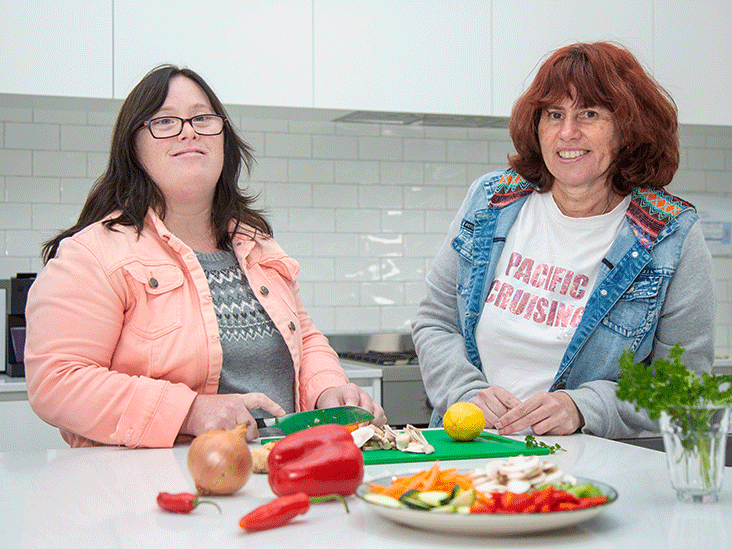Two woman chopping vegetable in the kitchen
