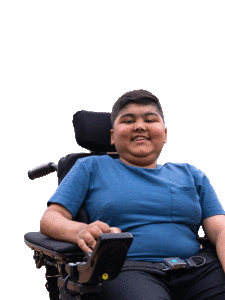 A boy smiling in his power wheelchair