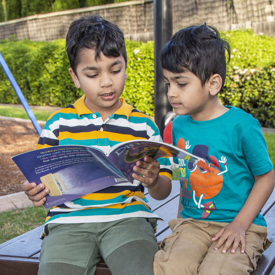 Two boys reading in the playground