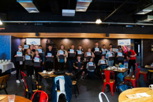 Group of customers holding up awards at the camera