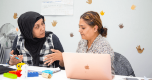 Two females sitting down talking to each other