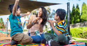 therapist sitting down playing with two young boys