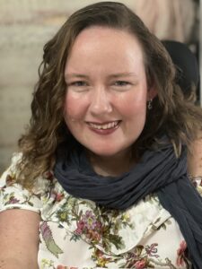 A woman with curly hair wearing a scarf