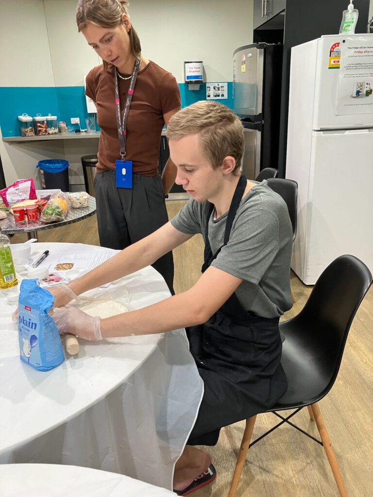 Boy rolling pizza dough in kitchen