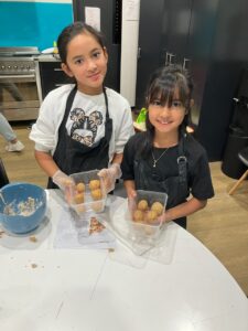 Two girls in kitchen making snacks