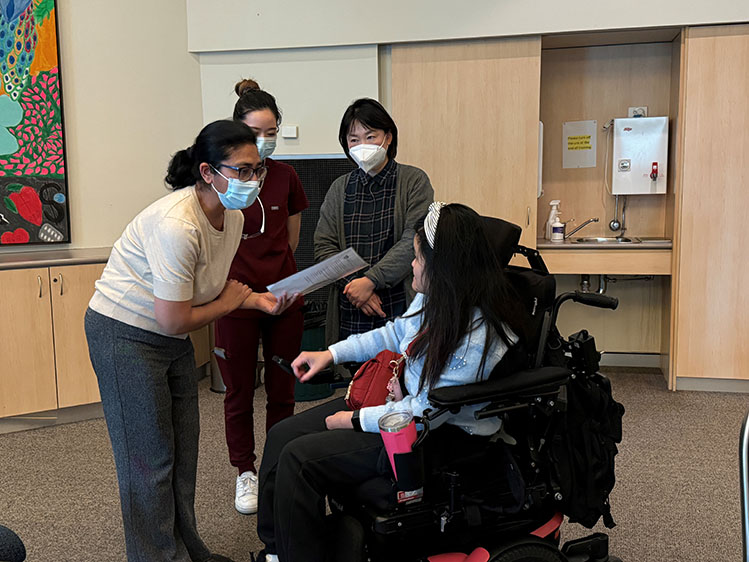 Person in wheelchair interacts with dentists