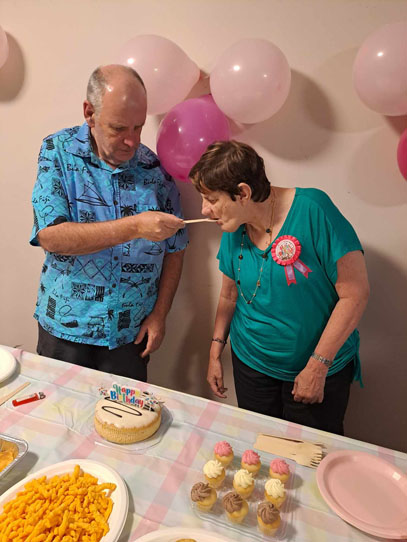 Man feeding woman cake