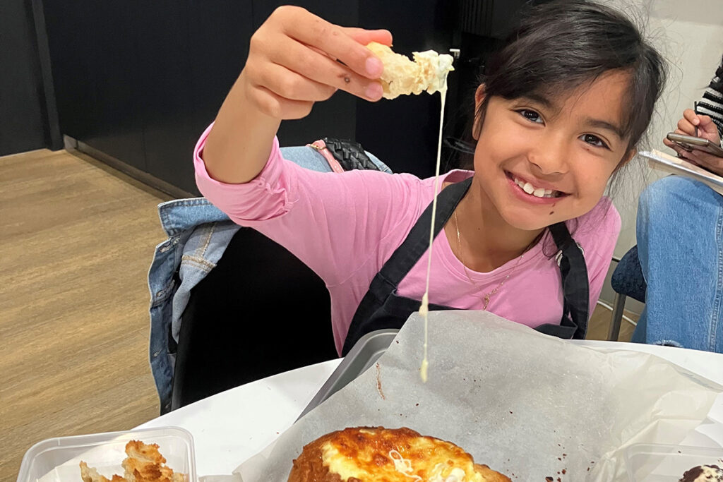 A young girl smiles as she shows off her baking